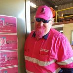 A man with a pink beard, hat and workwear