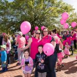 A family in pink with pink balloons