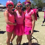 Three woman in pink on a tennis court