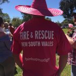 A man wearing a pink hat and pink Fire & Rescue shirt