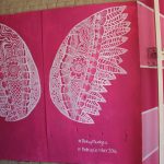 A Pink Up Mudgee mural with white wings on a pink background