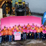 Group photo of Peabody workers in front of a pink scrapper