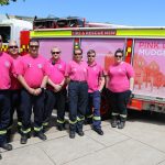 Firefighters wearing pink shirts next to a Pink Up Mudgee truck